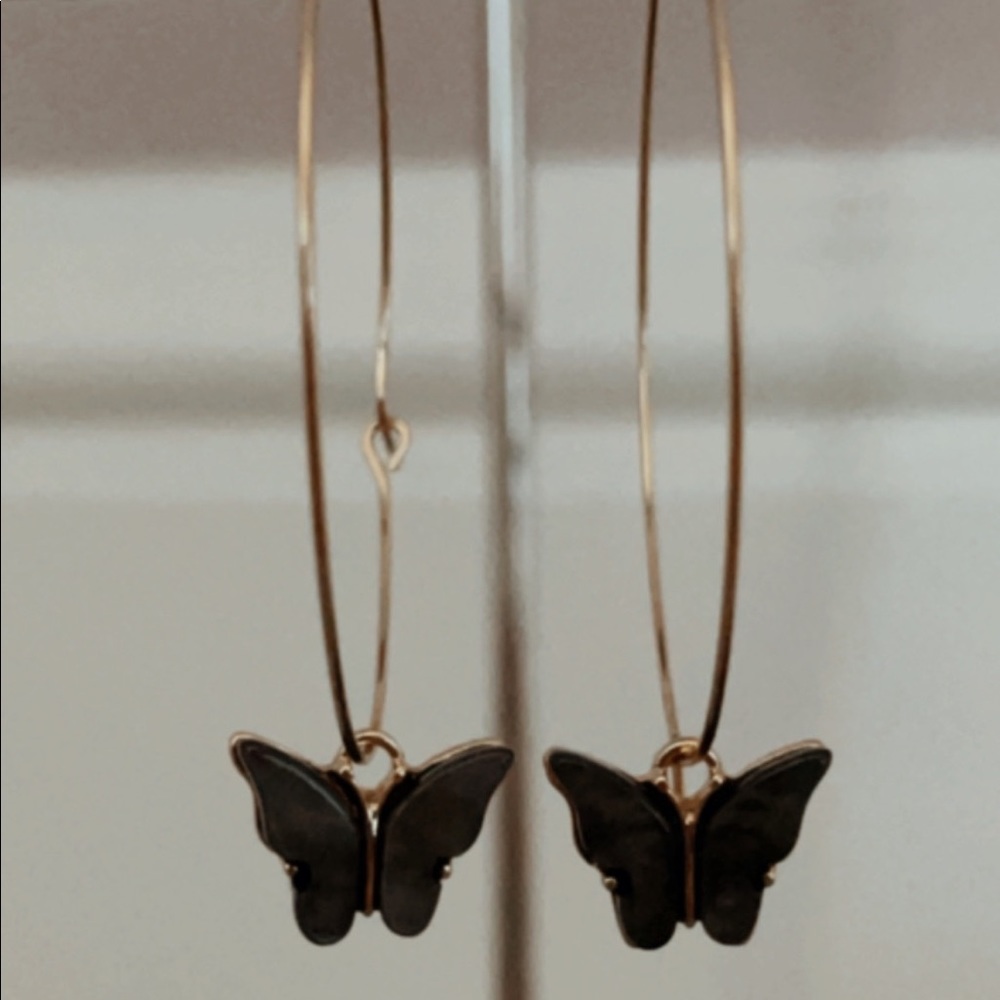 medium gold hoop earrings with a black butterfly